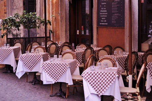 Outdoor restaurant tables with checked tablecloths in Rome.